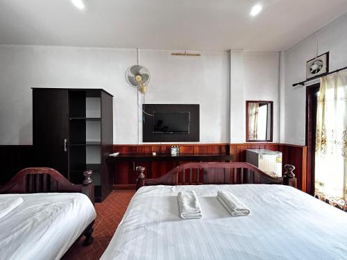 万荣Domon Riverside Hotel的卧室配有一张床,墙上配有电视。