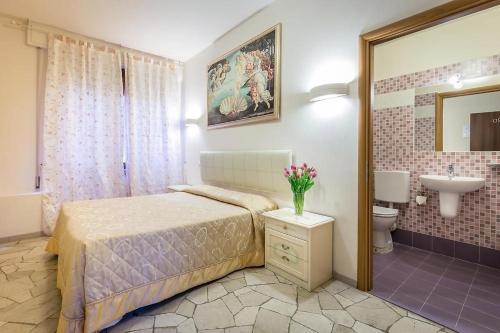 佛罗伦萨阿卡迪亚酒店的一间卧室配有一张床,浴室设有水槽