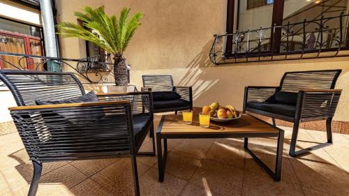 布加勒斯特特里亚侬酒店的庭院配有椅子和一张桌子及一碗水果