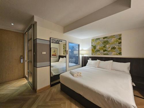 曼谷Somewhere to Escape - Hometel的卧室配有一张白色大床和镜子