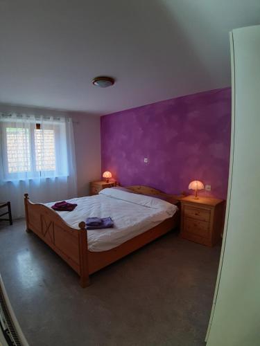 CavergnoCasa Allegra- appartamento Calla的一间卧室配有一张床和紫色的墙壁