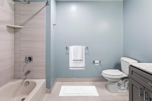怀尔德伍德Seaport Suites的带浴缸、卫生间和盥洗盆的浴室