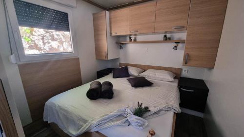 克罗诺维察Luxury Mobile Homes - Adria Superior的小卧室配有一张带两顶帽子的床