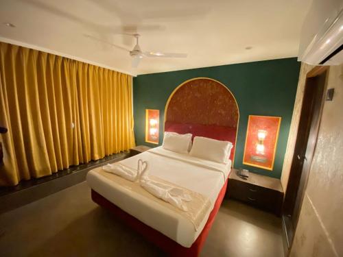 孟买Gulf Hotel Mumbai- The Boutique Hotel Colaba Mumbai的一间卧室设有一张大床,墙壁红色和绿色