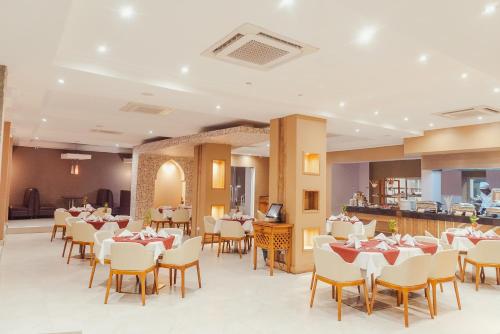 坦噶Tanga Beach Resort & Spa的一间带桌椅的用餐室和一间酒吧