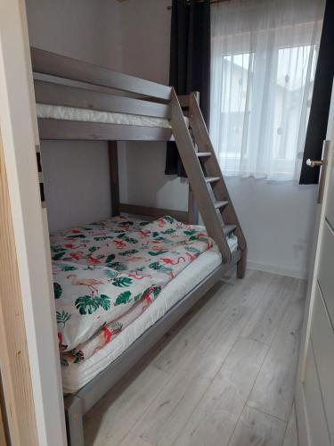 萨比诺瓦Domki Letniskowe Family Dreams的配有床单的客房内的双层床