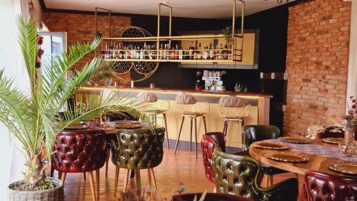 特尔古-塞奎斯Villa Westfalia Guest House的一间带桌椅的餐厅和一间酒吧