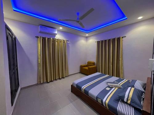 科托努MonGite的一间卧室配有一张蓝色天花板的床