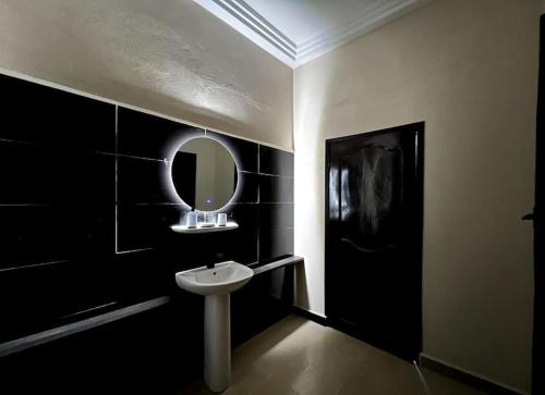 科托努MonGite的浴室设有水槽和墙上的镜子