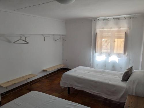 比亚尔Casa Malena - Biar的白色的客房设有两张床和窗户。