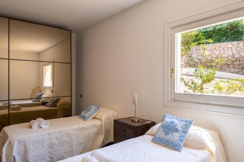 利斯西亚迪维卡Ampio Appartamento 4 Minuti a Piedi dal Mare的一间卧室配有两张床和镜子