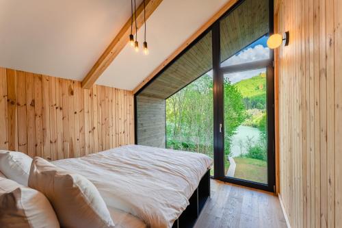 TeşilaVila ZIA的一间卧室设有木墙和大窗户
