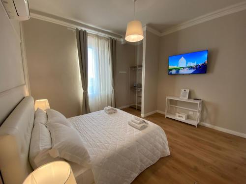 比萨FOUR LIONS VILLA GUESTHOUSE的卧室配有白色的床和平面电视。