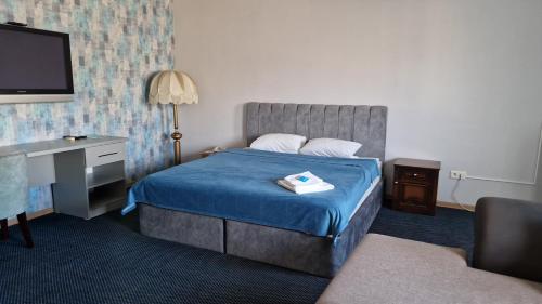阿克套维多利亚酒店的酒店客房配有一张床、一张书桌和一台电视。