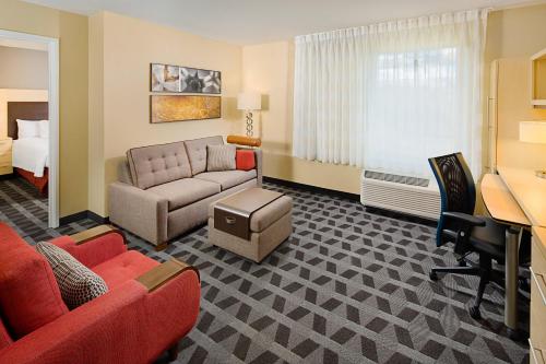 约翰逊费耶特维尔N /斯普林万豪广场套房酒店.的酒店客房设有一张沙发和一张床