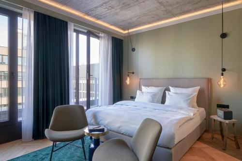 美因河畔法兰克福Gekko House Frankfurt, a Tribute Portfolio Hotel的一间卧室配有一张床、两把椅子和窗户