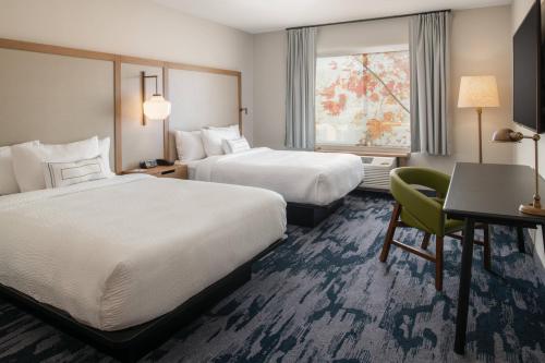 韦纳奇Fairfield Inn & Suites by Marriott Wenatchee的酒店客房设有两张床、一张书桌和一个窗户。