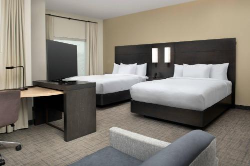 多拉Residence Inn Doral Mall Area的酒店客房配有两张床和一张书桌