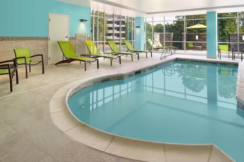 亚特兰大SpringHill Suites by Marriott Atlanta Northwest的一个带椅子和桌子的游泳池