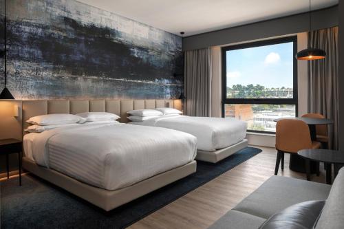 约翰内斯堡Johannesburg Marriott Hotel Melrose Arch的一间卧室设有两张床和大窗户