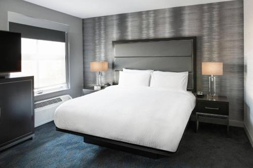 切尔西波士顿洛根机场/切尔西万豪酒店的卧室设有一张白色大床和一扇窗户。