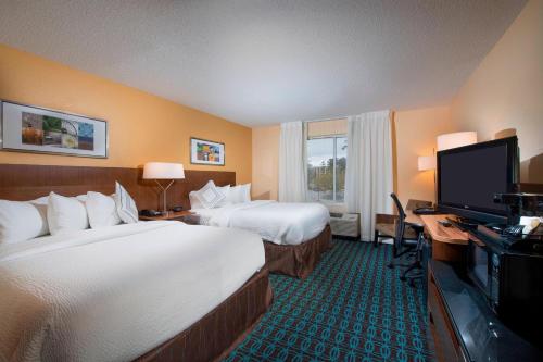 查尔斯顿北查尔斯顿/大学区费尔菲尔德套房酒店的酒店客房设有两张床、一张桌子和一台电视。