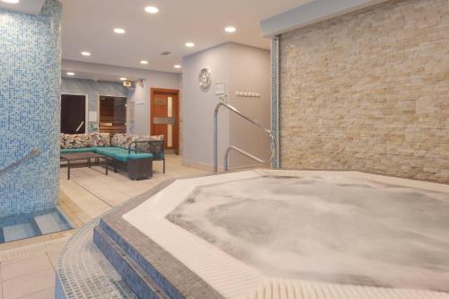 切尔滕纳姆Delta Hotels by Marriott Cheltenham Chase的按摩浴缸位于客房中间