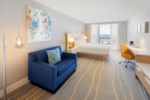 代托纳海滩阿卡普尔科度假酒店的酒店客房,配有一张床和一张蓝色椅子
