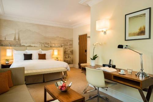 卢塞恩卢塞恩万丽酒店的配有一张床和一张书桌的酒店客房