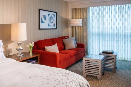伊丽莎白纽瓦克机场万丽酒店的酒店客房配有红色的沙发和床。