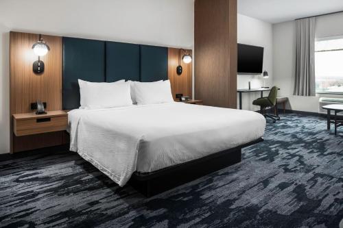 麦金尼Fairfield by Marriott Inn & Suites Dallas McKinney的酒店客房设有一张大床和一张书桌。