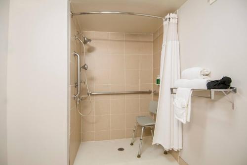 欧文万豪达拉斯沃斯堡机场南/欧文费尔菲尔德客栈的带淋浴、椅子和浴帘的浴室