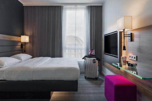 哥本哈根Moxy Copenhagen Sydhavnen的酒店客房设有一张床和一个大窗户