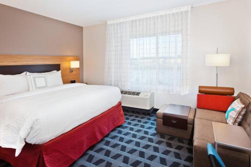 多森TownePlace Suites Dothan的酒店客房设有一张大床和一张沙发。