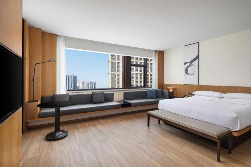杭州杭州萧山万枫酒店的一间卧室配有一张床、一张沙发和一个窗口
