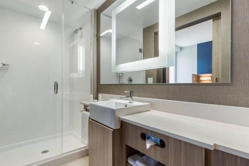 夏洛特SpringHill Suites Charlotte Southwest的一间带水槽、淋浴和镜子的浴室