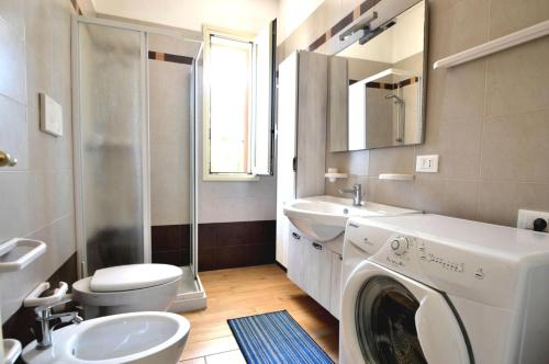 新福卡Villetta 6 posti vicino spiaggia的一间带洗衣机和水槽的浴室