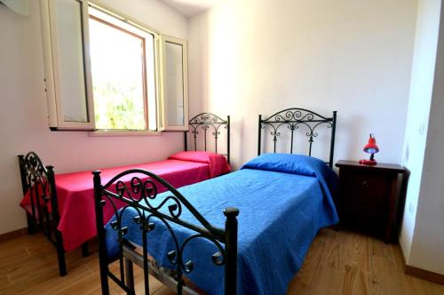 新福卡Villetta 6 posti vicino spiaggia的一间卧室设有两张床和窗户。
