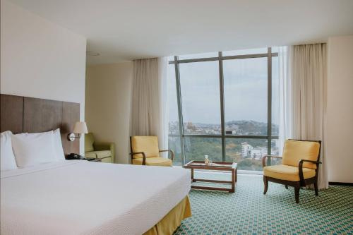 瓜亚基尔瓜亚基尔万豪酒店的酒店客房设有一张床和一个大窗户