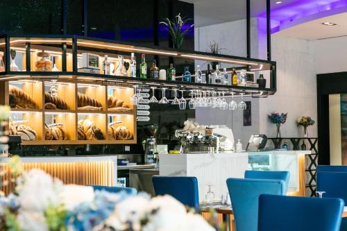 迪拜玛立纳比布鲁斯酒店的一间设有蓝色椅子的餐厅和一间酒吧