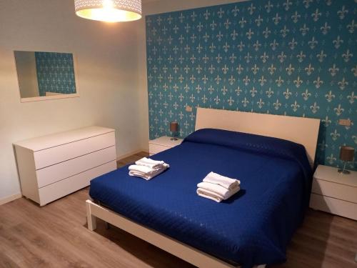 ColombaroCASA VACANZE FRANCIACORTA的一间卧室配有蓝色的床和2条毛巾