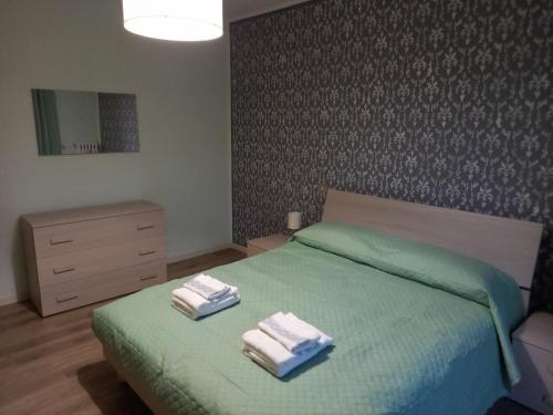 ColombaroCASA VACANZE FRANCIACORTA的一间卧室配有绿床和2条毛巾