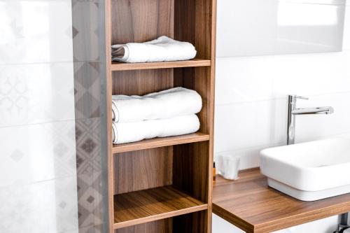 勒拉旺杜博赛特酒店的浴室设有木制架子、毛巾和水槽
