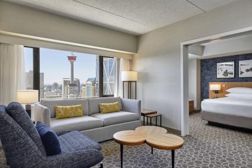 卡尔加里Delta Hotels by Marriott Calgary Downtown的酒店客房带床、沙发以及一间卧室