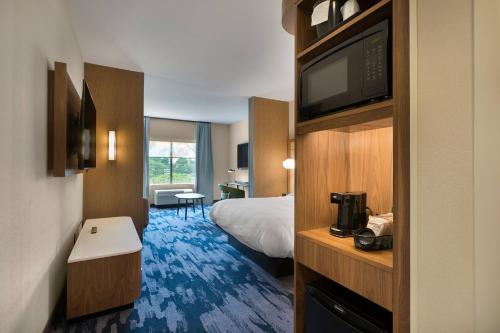 斯泰茨维尔Fairfield by Marriott Inn & Suites Statesville的配有一张床和一台平面电视的酒店客房