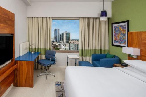 达累斯萨拉姆Four Points by Sheraton Dar es Salaam New Africa的酒店客房,配有一张床、一张桌子和椅子