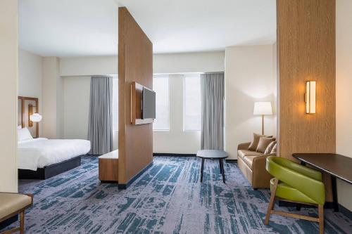 德梅因Fairfield Inn & Suites by Marriott Des Moines Downtown的酒店客房设有一张沙发和一台电视机。