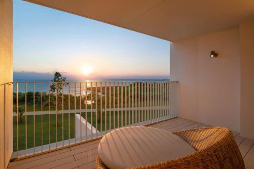 宫古岛IRAPH SUI, a Luxury Collection Hotel, Miyako Okinawa的阳台配有藤椅,享有海景。