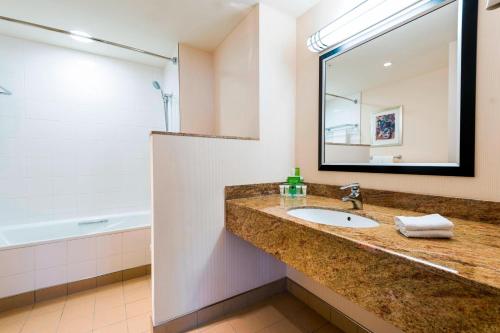 布拉格万豪布拉格市万怡酒店的浴室配有盥洗盆、镜子和浴缸