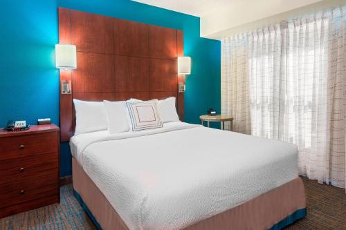 塔拉哈西塔拉哈斯北I-10首都圈酒店的一间卧室设有一张大床和蓝色的墙壁